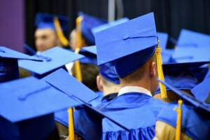 Graduation Ceremony With Blue Caps And Gowns.