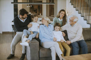 Multi Generation Family Sitting Together On The Sofa At Home And