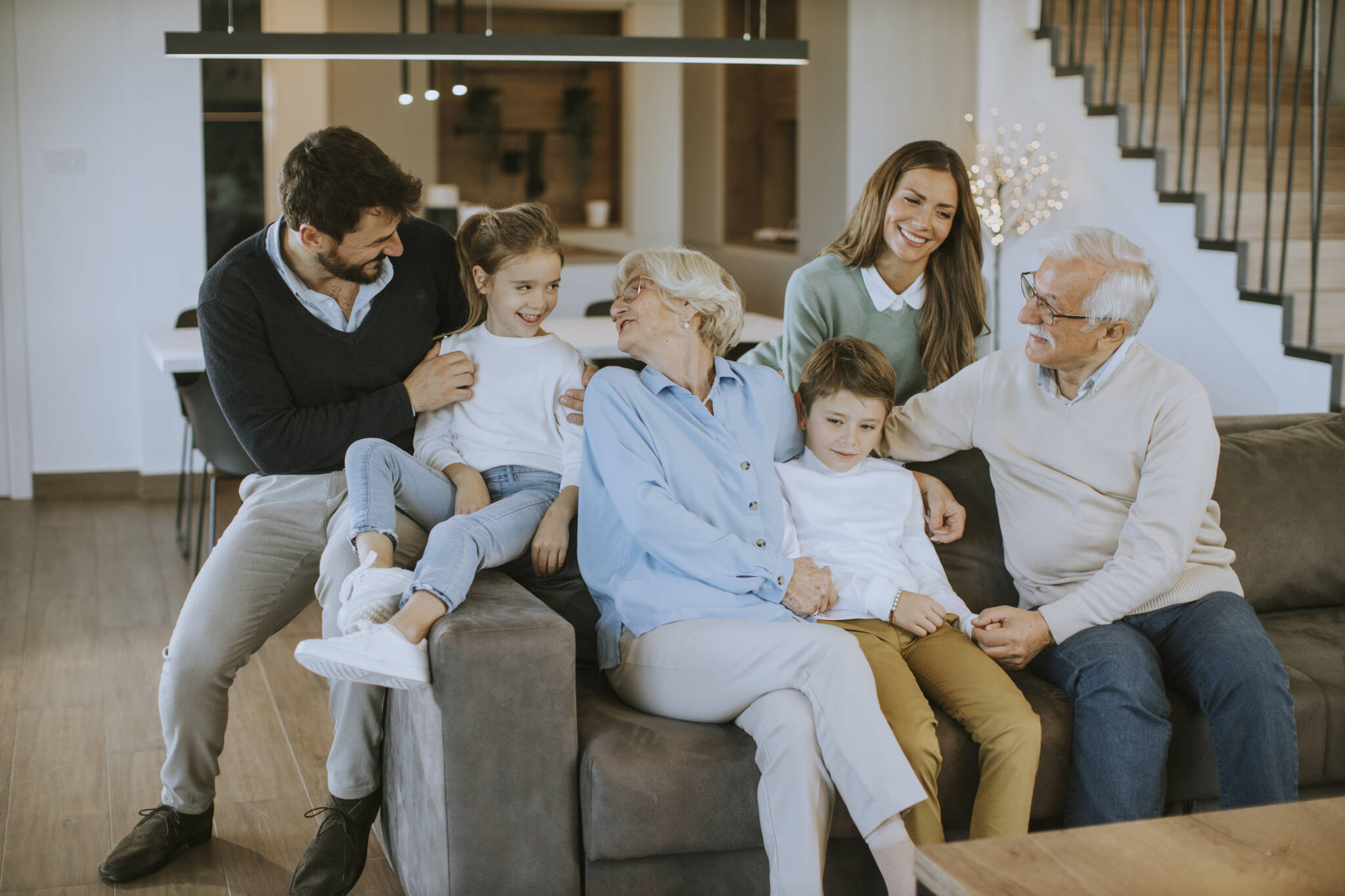 Multi Generation Family Sitting Together On The Sofa At Home And